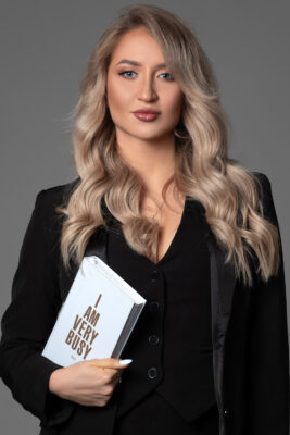 Professional business portrait of a woman holding a book — personal branding
