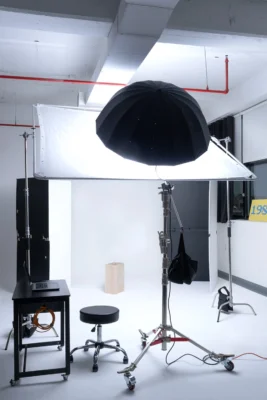 Brooklyn photo studio rental with large overhead softbox, black umbrella light, white seamless background and professional lighting setup